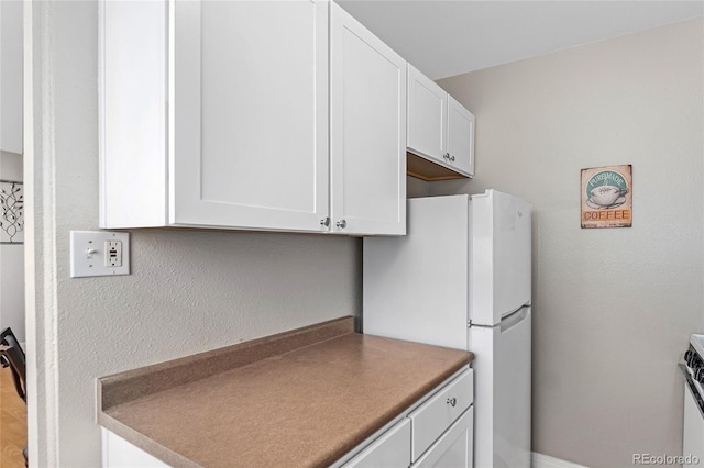 kitchen with white cabinetry and white refrigerator