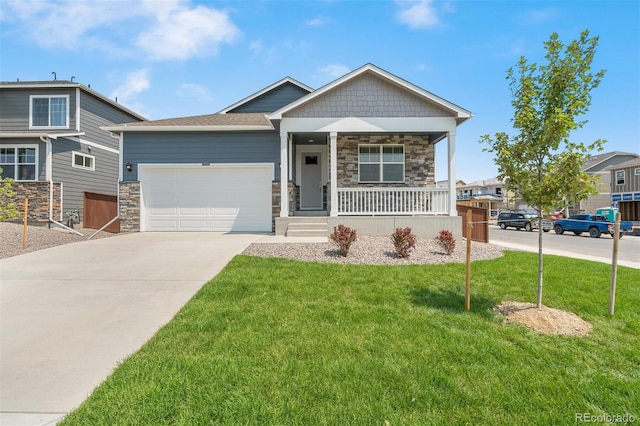 craftsman-style house featuring covered porch, a garage, and a front lawn