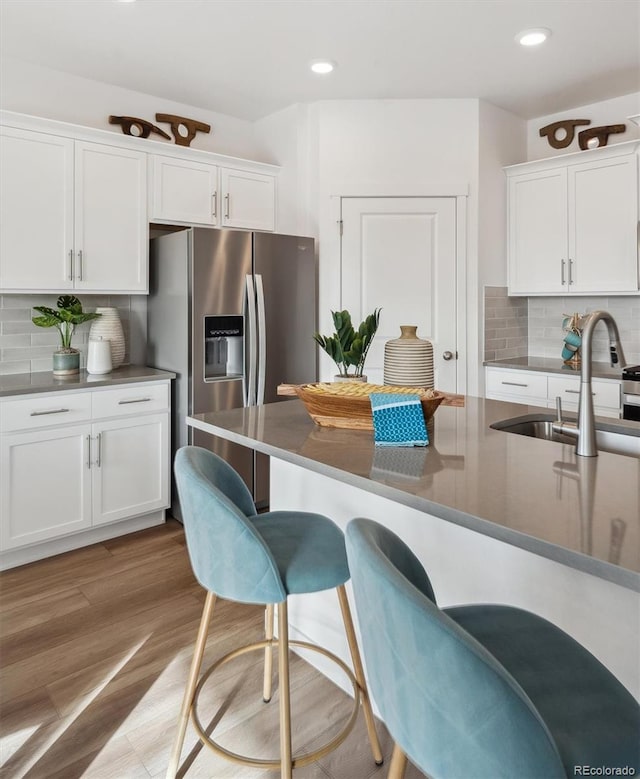 kitchen with sink, white cabinetry, and stainless steel fridge with ice dispenser