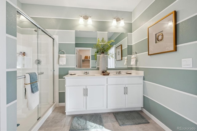 bathroom featuring tile patterned flooring, an enclosed shower, and vanity