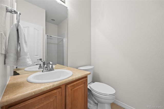 bathroom with a stall shower, vanity, and toilet