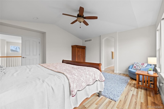 bedroom featuring a ceiling fan, baseboards, visible vents, vaulted ceiling, and light wood-type flooring