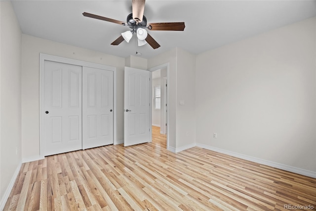 unfurnished bedroom with a closet, light wood-style flooring, and baseboards