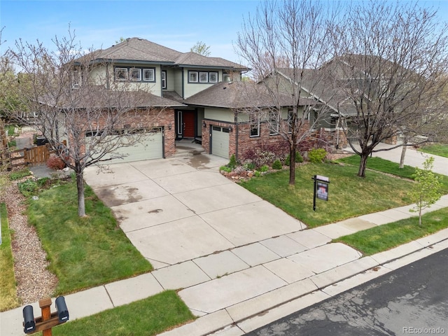 prairie-style home with fence, a shingled roof, a front yard, brick siding, and driveway