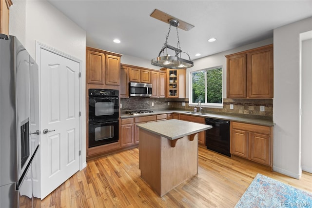 kitchen featuring brown cabinetry, black appliances, light wood finished floors, and tasteful backsplash