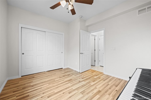 unfurnished bedroom featuring baseboards, a closet, light wood-style flooring, and visible vents