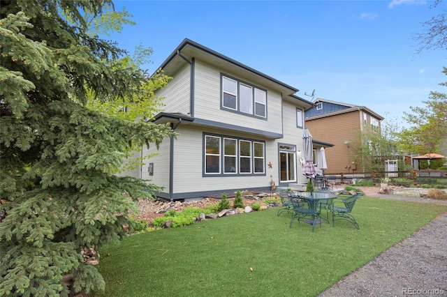 back of house featuring a yard and fence
