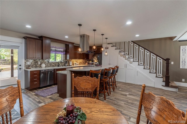 10640 W 46th Ave, Wheat Ridge, CO 80033 - kitchen featuring dishwasher, island exhaust hood, wood finished floors, light countertops, and recessed lighting