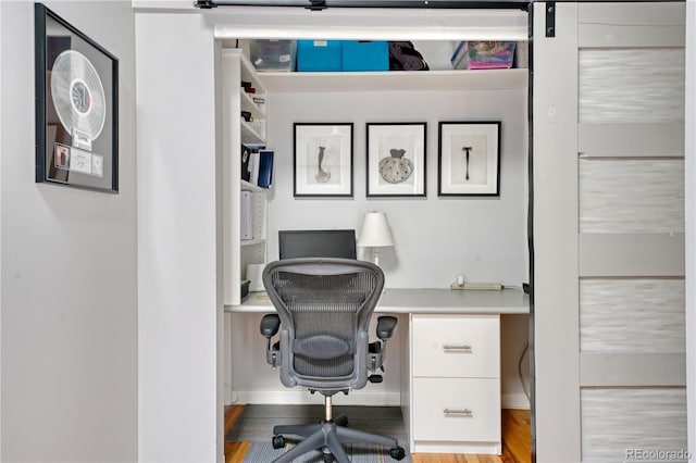 office space featuring a barn door and light wood-type flooring