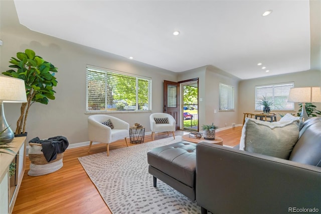 living room featuring baseboards, light wood-style flooring, and recessed lighting