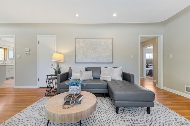 living room with light wood-style flooring, healthy amount of natural light, baseboards, and recessed lighting