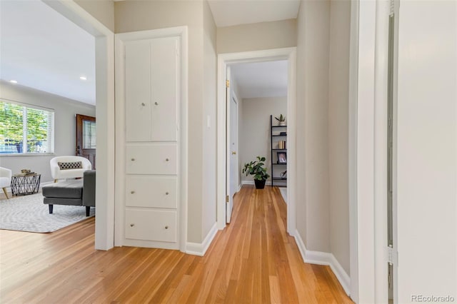 corridor with light wood-style floors, recessed lighting, and baseboards