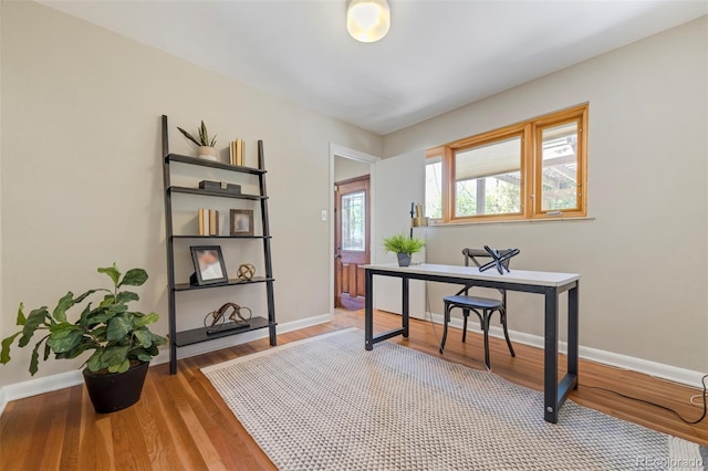 office area featuring baseboards and light wood-style flooring