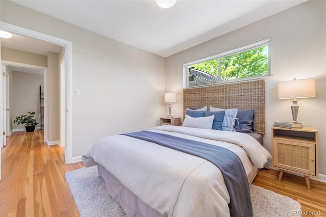 bedroom with light wood finished floors and baseboards
