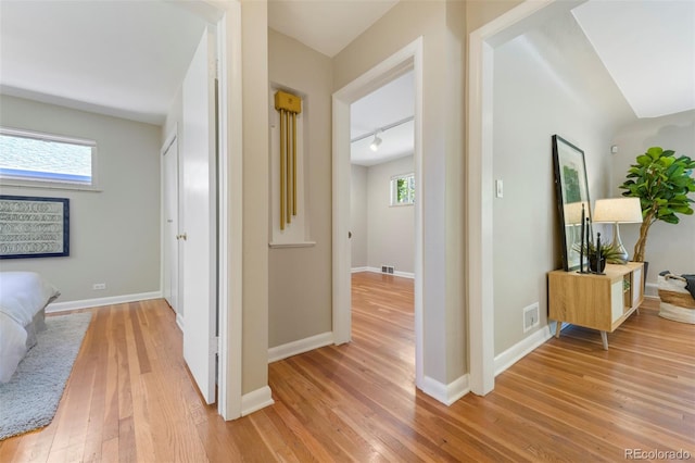 hallway featuring light wood-style floors and baseboards