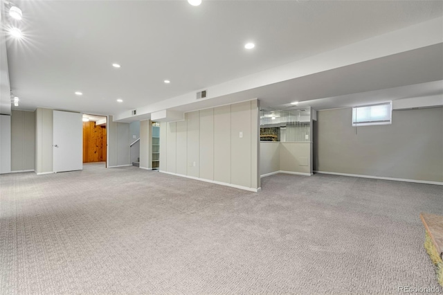below grade area with light colored carpet, baseboards, and recessed lighting