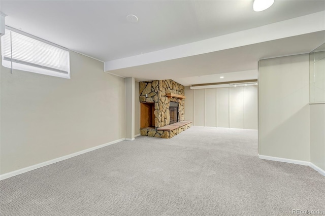 finished below grade area featuring carpet, a fireplace, and baseboards
