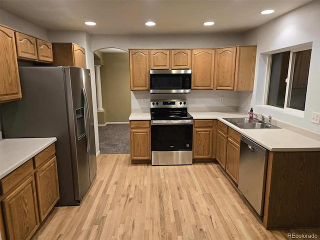 12742 Clermont St, Thornton, CO 80241 - kitchen with appliances with stainless steel finishes, arched walkways, a sink, light wood-type flooring, and recessed lighting