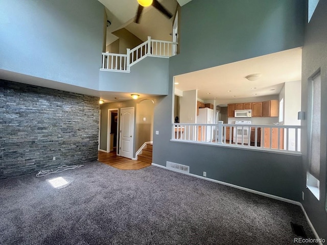 12742 Clermont St, Thornton, CO 80241 - unfurnished living room with carpet, a towering ceiling, stairway, and baseboards