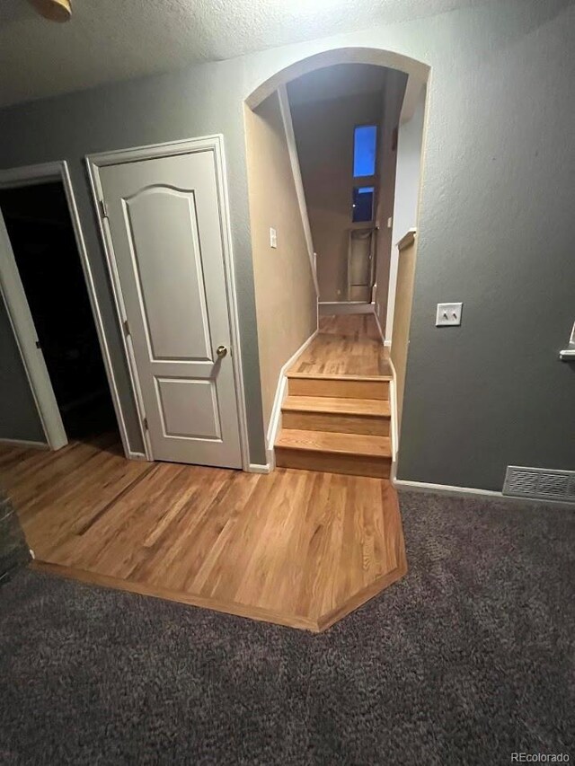 12742 Clermont St, Thornton, CO 80241 - staircase with arched walkways, wood finished floors, baseboards, and carpet
