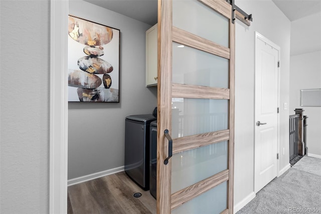 interior details featuring washer and dryer, a barn door, and carpet flooring