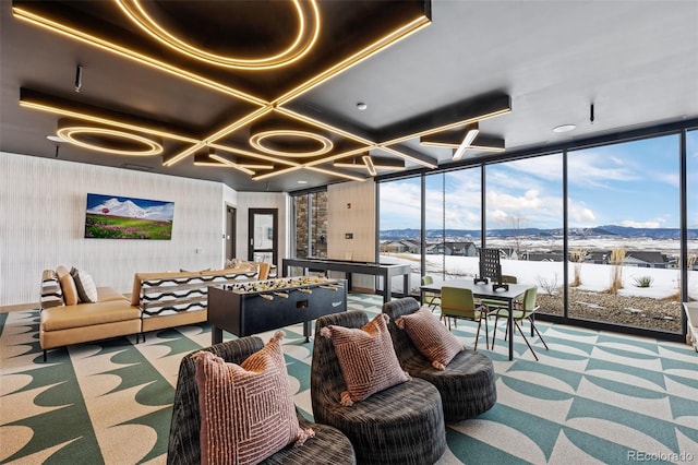 playroom with expansive windows, coffered ceiling, a mountain view, and carpet flooring