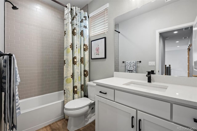 full bathroom with vanity, toilet, hardwood / wood-style floors, and shower / bath combo