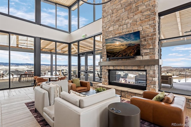 living room featuring a multi sided fireplace, a towering ceiling, and a wealth of natural light