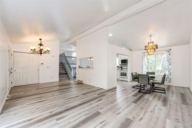 dining room with lofted ceiling with beams, stairway, light wood-type flooring, and a chandelier