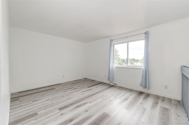 unfurnished room with visible vents, baseboards, and light wood finished floors