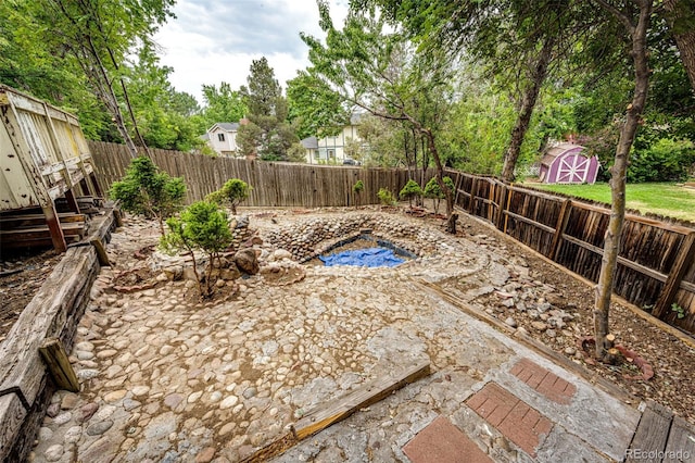 view of pool with a fenced backyard, a storage unit, and an outdoor structure