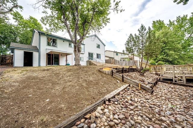 back of property with a garden and fence