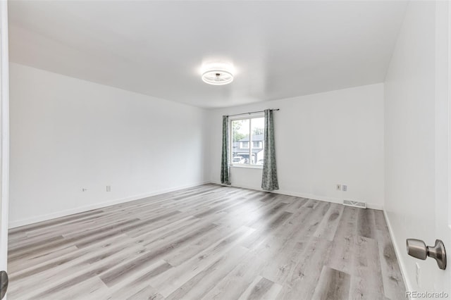 empty room with visible vents, baseboards, and light wood-style flooring