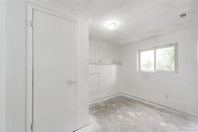 empty room featuring visible vents and a textured ceiling