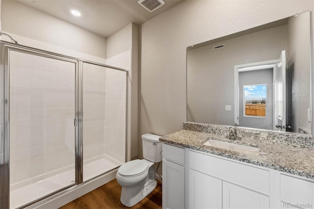 7326 Green River Ave, Frederick, CO 80530 - bathroom with wood finished floors, a stall shower, toilet, and vanity