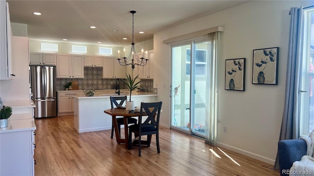 dining space featuring recessed lighting, baseboards, a chandelier, and light wood finished floors