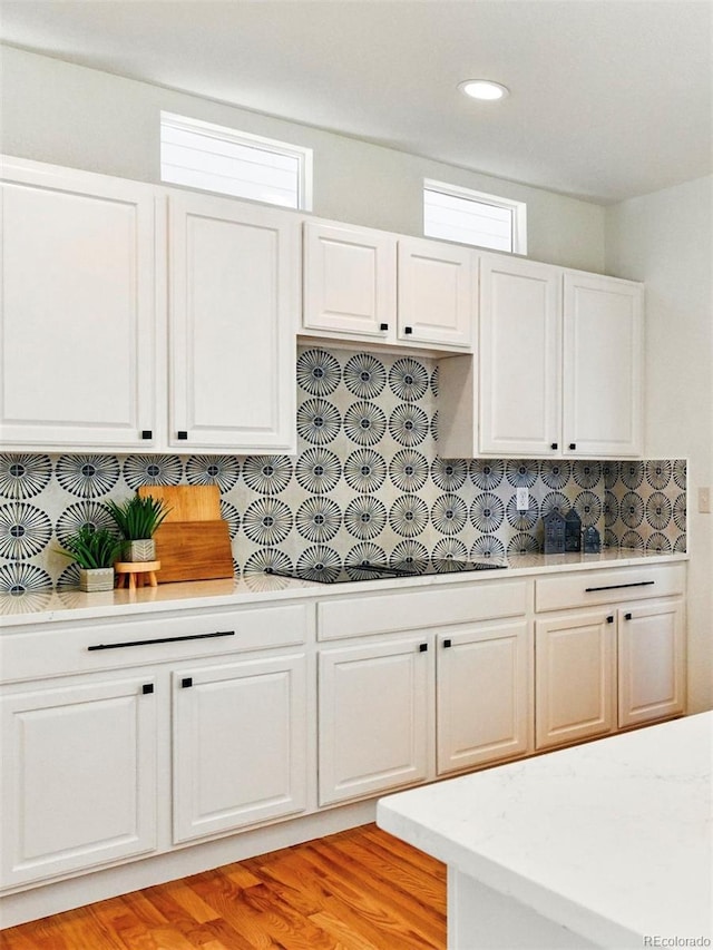 kitchen featuring recessed lighting, decorative backsplash, light wood finished floors, and white cabinetry