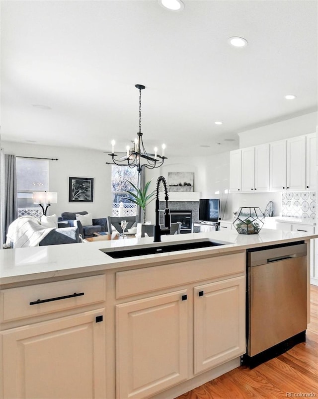 kitchen featuring open floor plan, a healthy amount of sunlight, dishwasher, and a sink