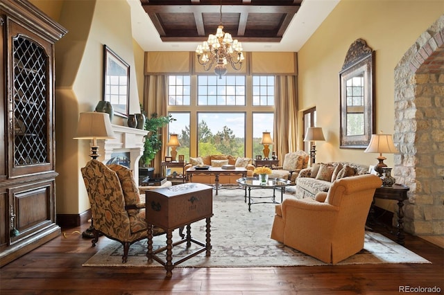 sitting room with a notable chandelier, dark hardwood / wood-style floors, a wealth of natural light, and coffered ceiling