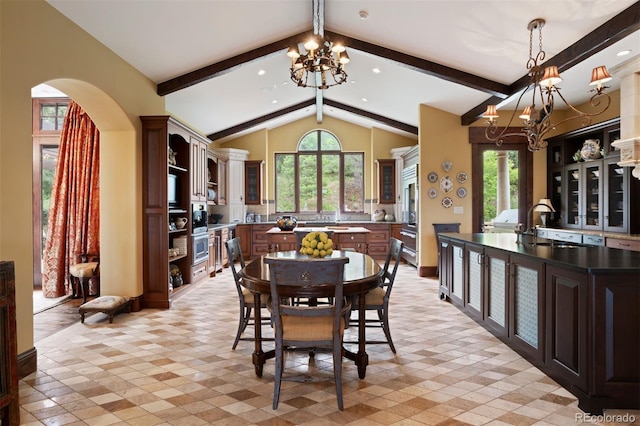 dining room with a chandelier, vaulted ceiling with beams, plenty of natural light, and sink