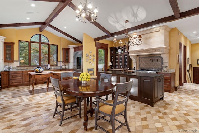 dining area featuring vaulted ceiling with beams, sink, a healthy amount of sunlight, and a notable chandelier