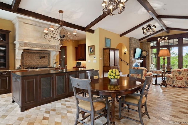 dining area featuring lofted ceiling with beams and sink