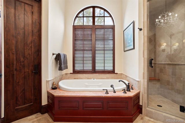 bathroom featuring a notable chandelier and independent shower and bath