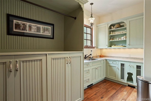 kitchen with pendant lighting, light hardwood / wood-style floors, and sink