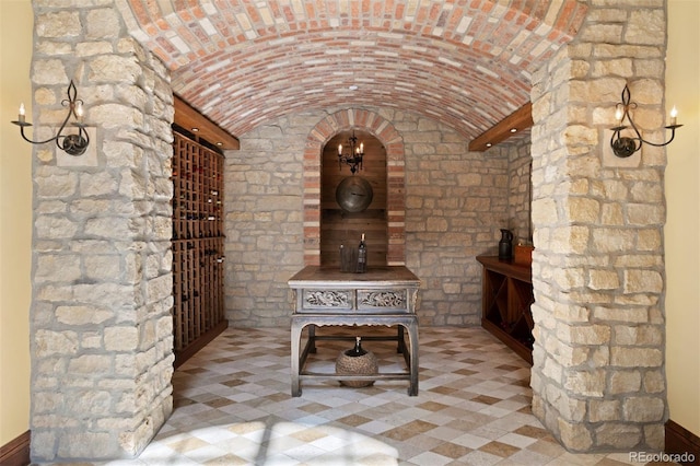 wine cellar featuring brick ceiling and vaulted ceiling