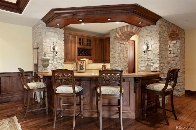 bar with dark hardwood / wood-style floors, ornamental molding, and tasteful backsplash