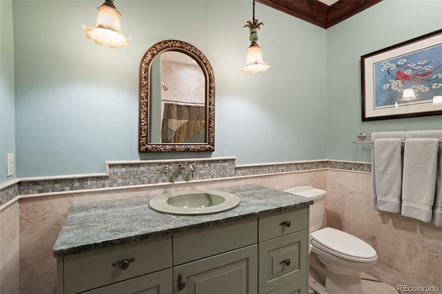 bathroom featuring crown molding, vanity, tile walls, and toilet