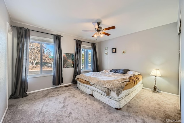 carpeted bedroom with multiple windows and ceiling fan