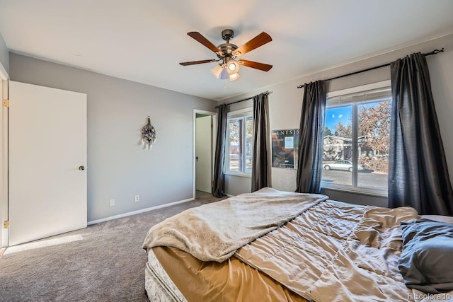 bedroom featuring ceiling fan, multiple windows, and carpet