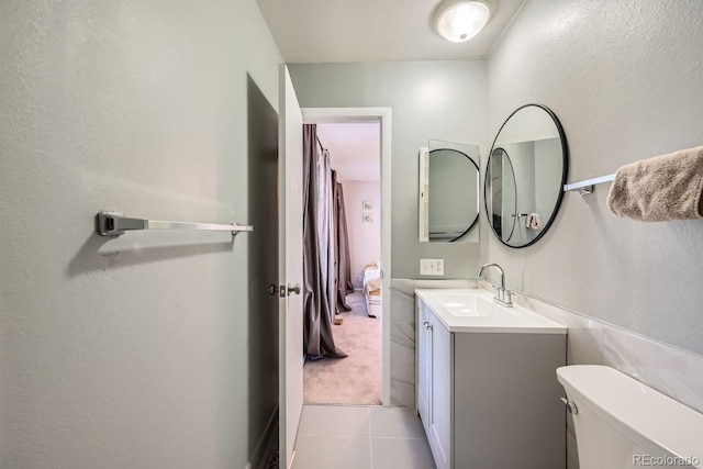 bathroom with tile patterned flooring, vanity, and toilet